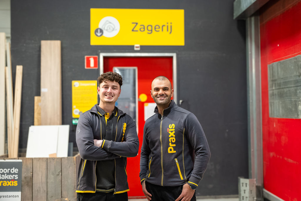 Vrouw met glimlach en mobiel in haar hand in een winkel.